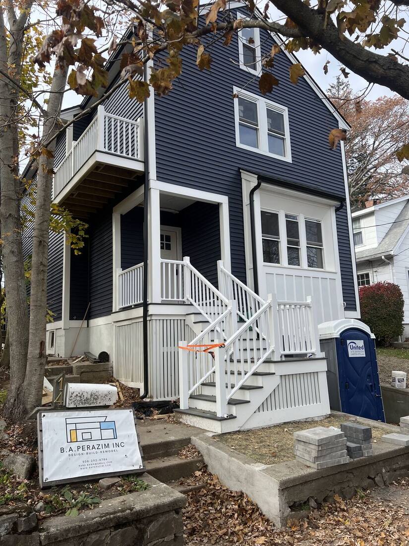 Navy siding, white porch railings and new front stairs complete