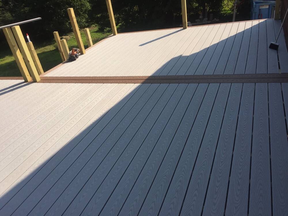 Gray composite deck boards with a brown accent border