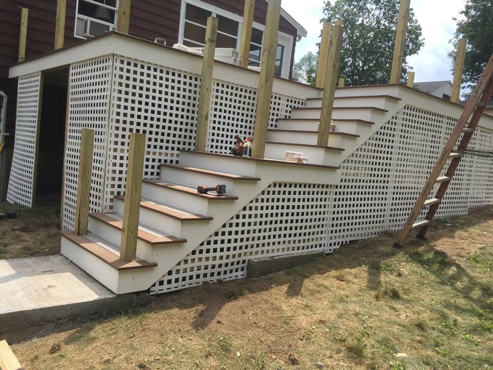 Two-flight stairs with brown treads and white lattice skirting
