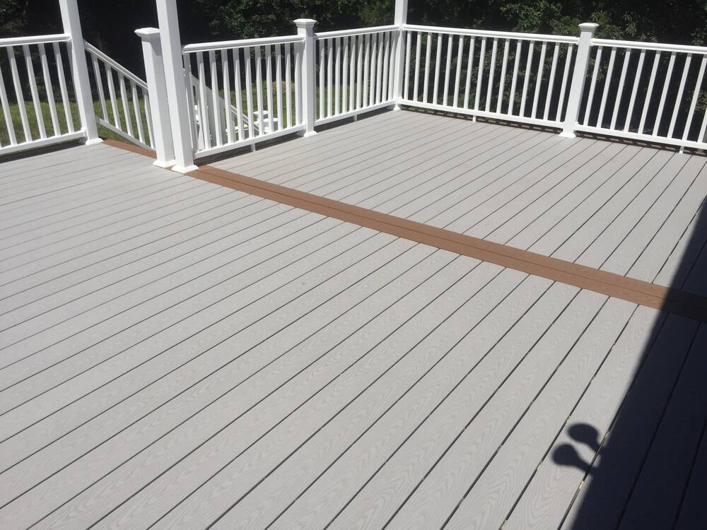 Finished gray composite deck with brown accent board and white railings