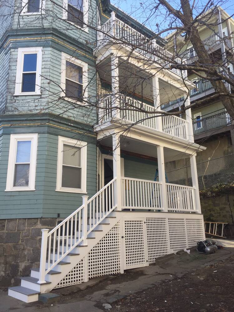 Finished two-story front porches with white railings, columns and lattice skirting