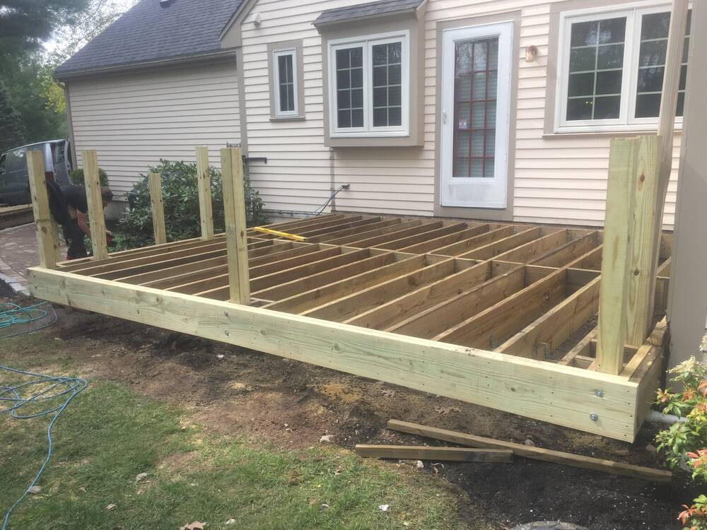 New deck frame with posts set against the house