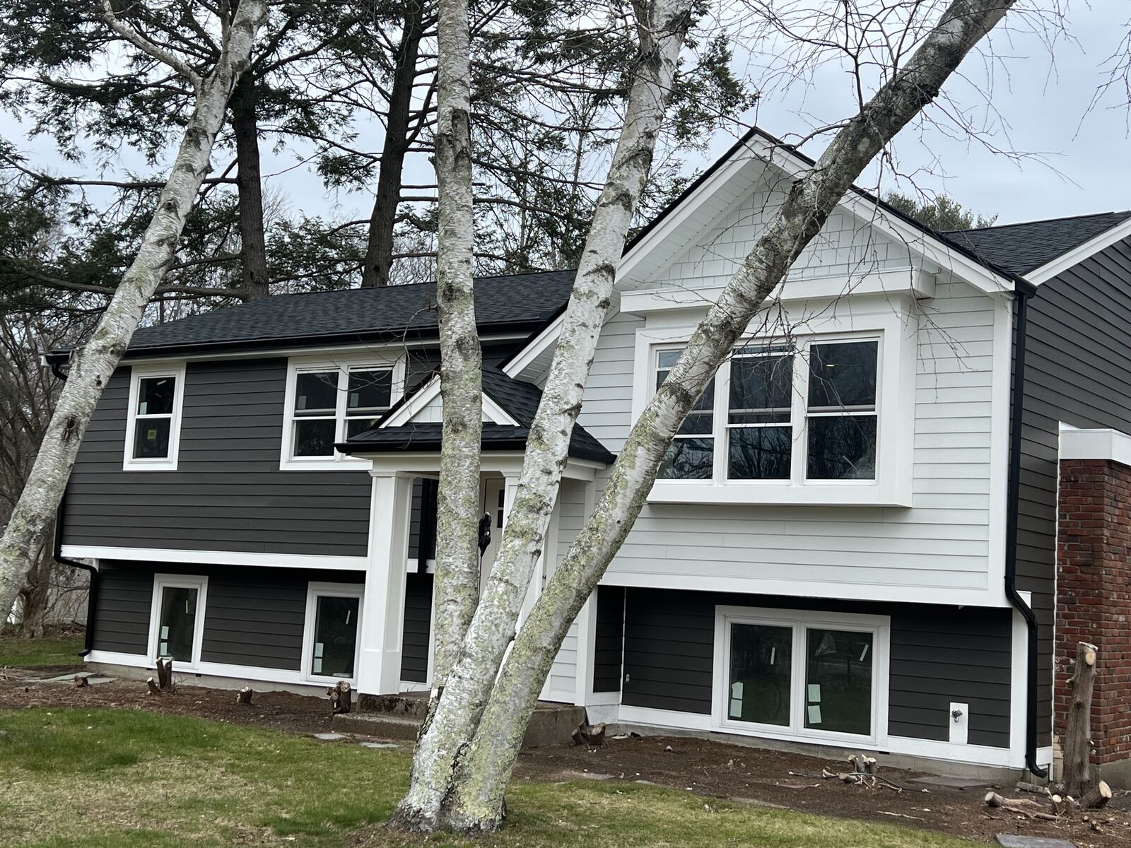 Split-level home with new gable bump-out, portico, siding, roof and windows
