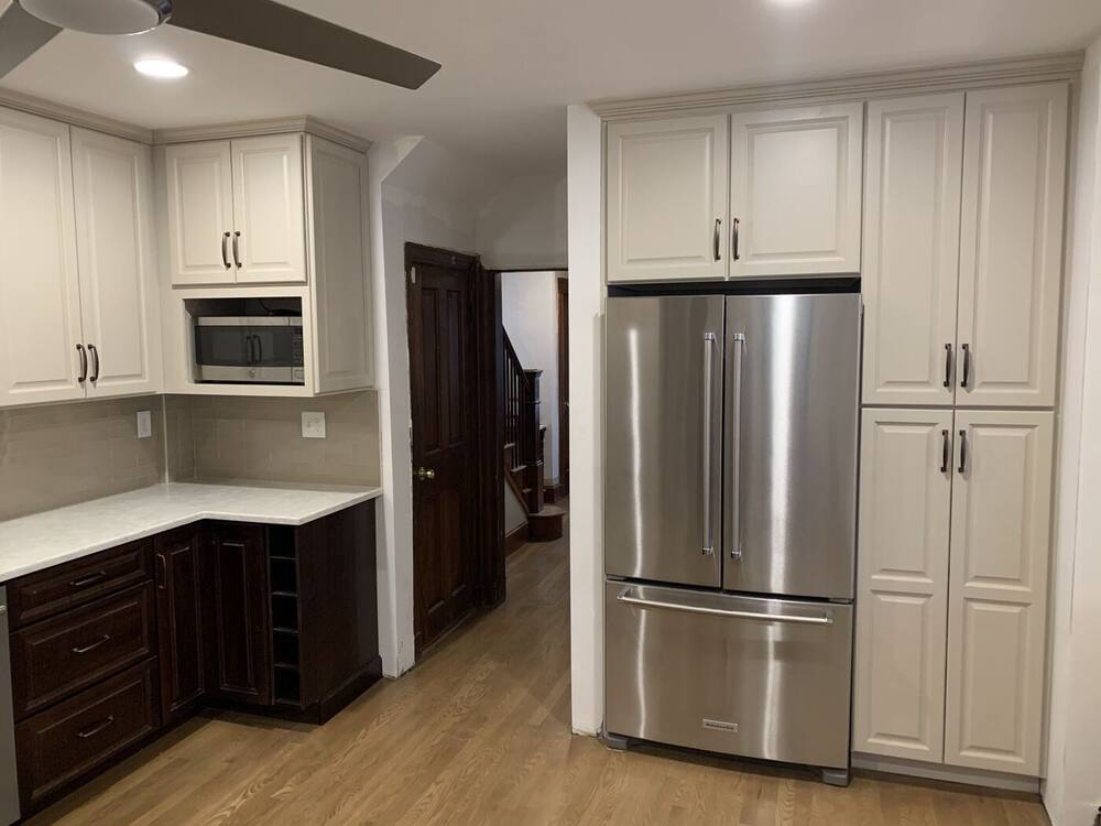 White pantry cabinets with built-in microwave and stainless French-door refrigerator