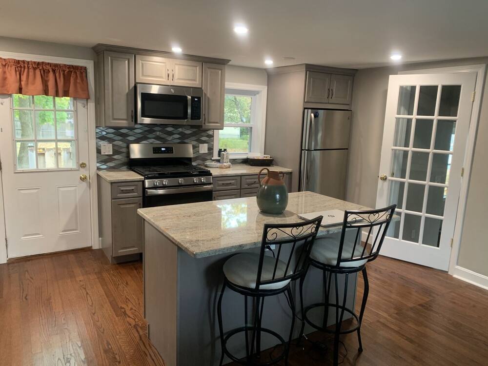 Granite island with bar stools and French doors beyond